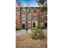 Charming brick townhome featuring blue shutters, a landscaped front yard, and a welcoming entrance at 479 Josephine St, Denver, CO 80206