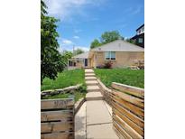 Charming home with a well-manicured lawn and inviting walkway to the front door at 951 Tennyson St, Denver, CO 80204