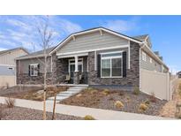 Charming home exterior featuring stone accents, gray siding, and manicured landscaping at 5108 N Quatar St, Aurora, CO 80019