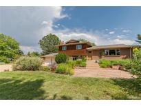 Charming two-story home with a well-manicured lawn, mature trees, and beautiful landscaping creating an inviting curb appeal at 8836 Marathon Rd, Longmont, CO 80503