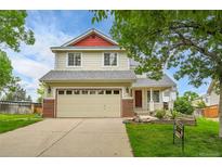 Charming two-story home with a two-car garage, red accents, and a well-manicured front yard at 5023 Goshawk Ct, Brighton, CO 80601