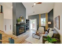 Inviting living room features a fireplace, hardwood floors, a ceiling fan and a sliding glass door to the deck at 11358 W 85Th Pl # E, Arvada, CO 80005