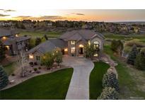 Beautiful home exterior with manicured lawn and long driveway leading up to a stone and stucco facade at 5409 Sedona Dr, Parker, CO 80134