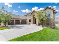 Stunning stone home with a three-car garage and a beautifully landscaped front yard with a circular driveway at 5409 Sedona Dr, Parker, CO 80134