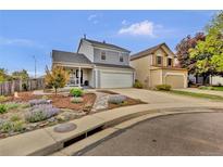 Two-story home with charming curb appeal, a front porch, a two-car garage, and colorful landscaping at 14430 W Yale Pl, Lakewood, CO 80228