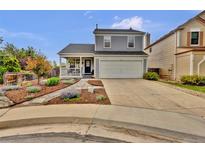 Charming two-story home with a covered front porch, two-car garage, and well-manicured landscaping at 14430 W Yale Pl, Lakewood, CO 80228