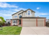 Charming two-story home featuring manicured front lawn, a three car garage, and brick accents at 133 Heritage Ave, Castle Rock, CO 80104