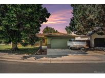 Charming single-story home with mature trees, a lawn, and attached garage at 1641 Biscay Cir, Aurora, CO 80011