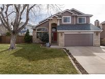 Charming two-story home featuring a well-maintained lawn, brick accents, and attached two-car garage at 1738 Jules Ct, Highlands Ranch, CO 80126