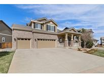 Inviting home with a three car garage, brick accents and covered front porch at 512 Cardens Pl, Erie, CO 80516