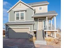 Inviting two-story home with a covered porch, attached garage, and manicured landscaping at 16347 E 111Th Dr, Commerce City, CO 80022