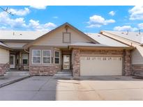 Inviting exterior showcasing a two-car garage and charming stone accents at 23590 E Jamison Pl, Aurora, CO 80016
