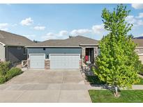 Charming exterior showcasing a two-car garage, stone accents and a lush green lawn at 9139 Flora St, Arvada, CO 80005