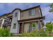 Modern two-story home boasts a red door and landscaped front yard with pink flowers at 1310 Hoyt St # 6, Lakewood, CO 80215