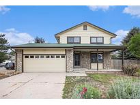 Charming two-story home with stone accents, a two-car garage, and a well-maintained front yard at 14190 E Gunnison Pl, Aurora, CO 80012