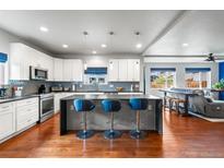 Spacious kitchen features an island with bar seating, stainless steel appliances, and hardwood flooring at 1353 Quaker St, Golden, CO 80401