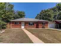 Charming red brick home with a well-maintained front yard and attached one car garage at 9150 Lilly Ct, Thornton, CO 80229