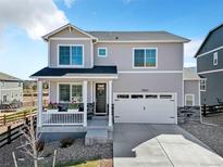 Charming two-story home boasts a two-car garage, covered front porch, and manicured landscaping, enhancing curb appeal at 15833 Little Bluestem Rd, Monument, CO 80132