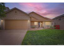 Charming single-Gathering home with a manicured lawn, covered porch, and brick accents on the garage and entrance at 5394 S Valdai Way, Aurora, CO 80015
