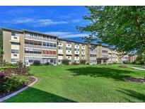 Well-maintained apartment building featuring manicured lawn and garden beds with a blue sky backdrop at 635 S Alton Way # 6A, Denver, CO 80247