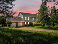 Charming two-story home with a three-car garage and a beautiful, sprawling lawn at 11824 E Basswood Ln, Franktown, CO 80116