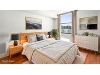 Bright bedroom with modern furniture, a large window with city views, and stylish decor at 1301 Speer Blvd # 702, Denver, CO 80204