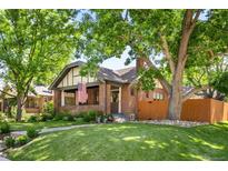 Charming brick home with a lush green lawn and mature trees providing ample shade and curb appeal at 2604 Elm St, Denver, CO 80207