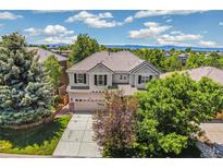 Two-story home features a well manicured front yard with mature trees and a neutral color scheme at 3411 Springbriar Dr, Castle Rock, CO 80109