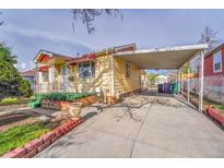Charming single-Gathering home with a covered parking and well-maintained front yard with flowerbeds at 4940 Adams St, Denver, CO 80216
