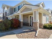 Inviting condo entrance featuring stone accents, well-kept landscaping, and a welcoming porch at 13708 Legend Trl # 101, Broomfield, CO 80023