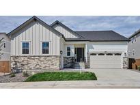 Charming exterior featuring stone accents, white siding, and a two-car garage at 9197 Ironwood St, Highlands Ranch, CO 80129
