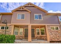 Charming townhouse with stone accents, covered entryway, neutral paint, and beautiful blue sky at 5660 S Algonquian Way # A, Aurora, CO 80016