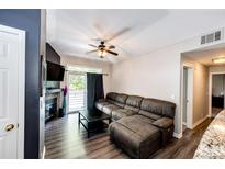 Cozy living room features a fireplace, balcony access, and comfortable sectional sofa at 8500 E Jefferson Ave # 19B, Denver, CO 80237