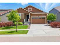 Charming single-Gathering home with a well-manicured lawn, stone accents, and a two-car garage at 8844 S Sicily Ct, Aurora, CO 80016