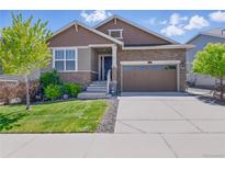 Charming two-story home featuring a stone facade, two-car garage, and well-maintained landscaping at 8844 S Sicily Ct, Aurora, CO 80016