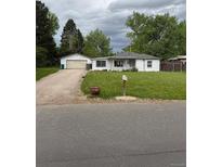 Charming single-story home with well-kept lawn, detached garage, and a welcoming front porch at 165 Garland St, Lakewood, CO 80226