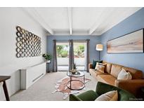 Bright living room featuring hardwood floors, a modern sofa, balcony access, and stylish decor at 551 N Pearl St # 207, Denver, CO 80203