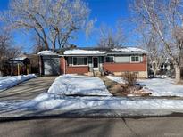 Brick ranch home with attached garage and snow-covered yard at 12289 W Dakota Dr, Lakewood, CO 80228