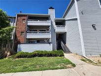 Two-story condo with light-blue siding, red brick accents, and a well-maintained grassy lawn and shrubs at 14499 E 1St Dr # A05, Aurora, CO 80011