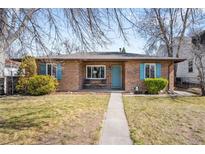 Charming brick home with a well-maintained lawn, blue shutters, and a cozy front porch at 2686 S Gilpin St, Denver, CO 80210