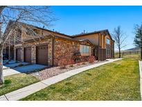 Beautiful two-story townhouse with brick and siding exterior and attached garages on a sunny day at 9816 W Freiburg Dr # A, Littleton, CO 80127