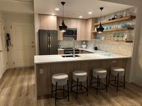 Modern kitchen with stainless steel appliances, wood cabinets and a breakfast bar with four stools at 1975 N Grant # 310, Denver, CO 80203
