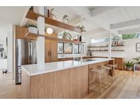 Modern kitchen with wood cabinets, white countertops, open shelving, stainless steel appliances, and light wood floors at 1423 S Eudora St, Denver, CO 80222