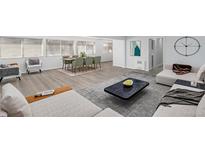 Sunlit living and dining area with modern decor and stylish gray wood flooring at 2203 S Holly St # 3, Denver, CO 80222