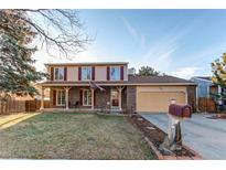 Charming two-story home with brick facade, covered porch, manicured lawn, and a two-car garage at 1149 S Kittredge St, Aurora, CO 80017