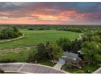 Stunning aerial view of home, landscape and open land with captivating sunset in background at 9765 W 77Th Dr, Arvada, CO 80005