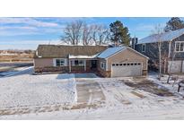 Inviting home showcasing a large front yard and attached two-car garage on a sunny winter day at 10092 Lee St, Broomfield, CO 80021