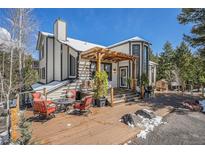 Beautiful home exterior with a wooden deck, pergola, and cozy seating area, perfect for enjoying the outdoors at 846 Circle K Ranch Rd, Evergreen, CO 80439