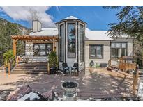 Stunning home exterior featuring a spacious deck and architectural details like a turret and pergola at 846 Circle K Ranch Rd, Evergreen, CO 80439