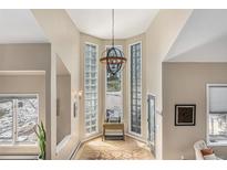 Bright foyer with glass block windows, high ceilings, and modern chandelier at 846 Circle K Ranch Rd, Evergreen, CO 80439